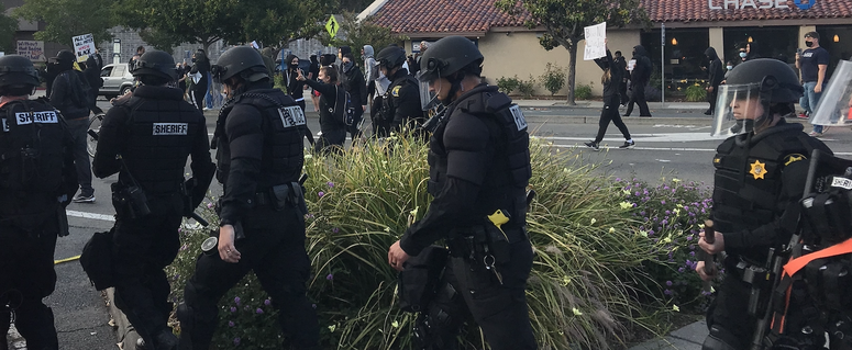 Officers in riot gear following demonstrators in downtown Walnut Creek on Sunday evening.